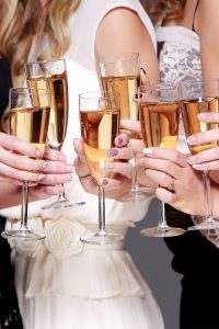 six glasses of champagne being held by people with painted nails