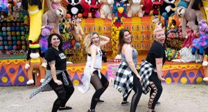 women twerking in front of carnival stand