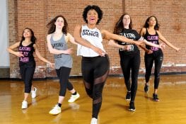 five women walking forward with hands out in dance studio