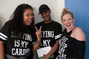 one man and two women in black divadance tshirts