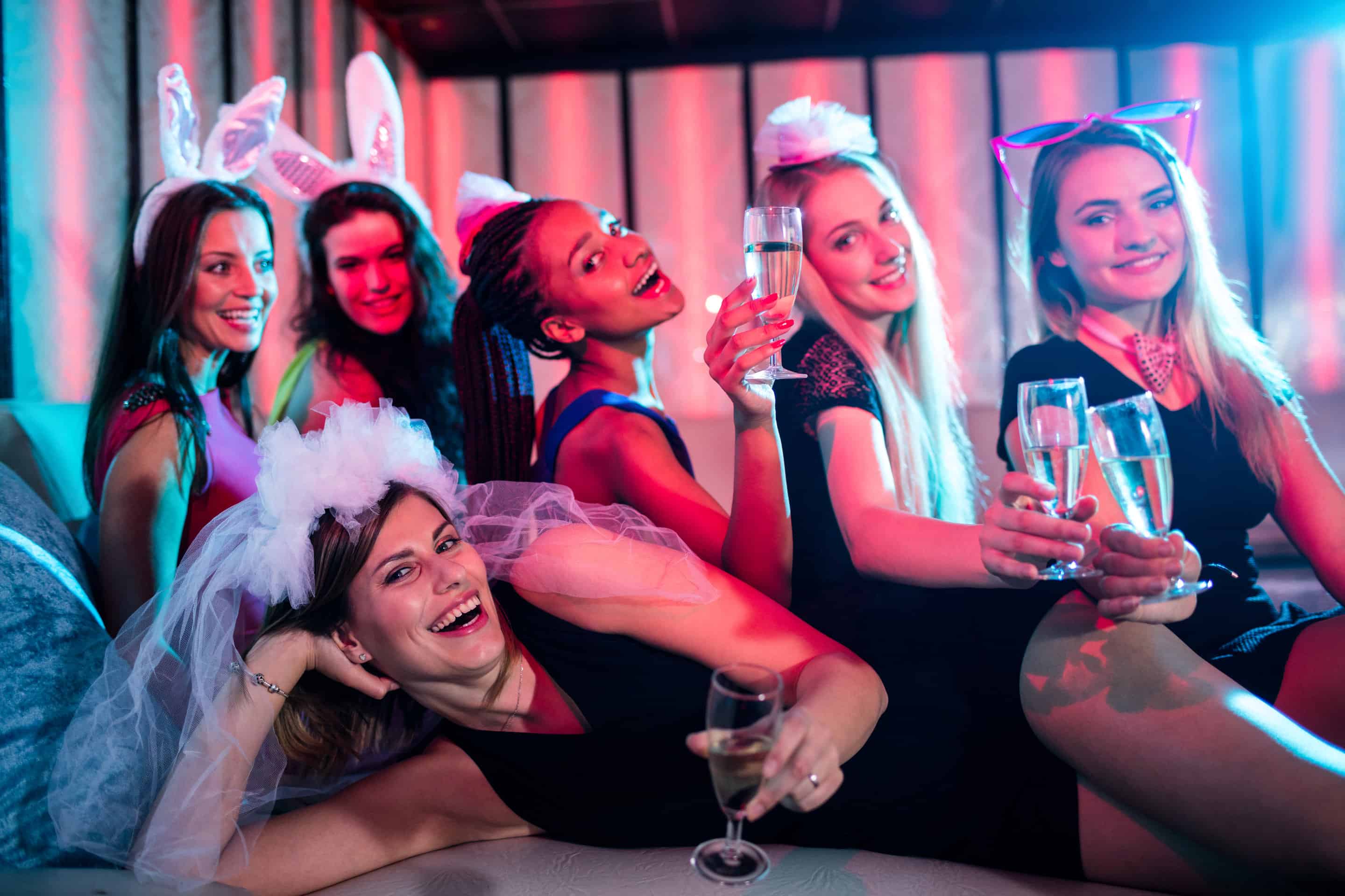 Group of women posing with glass of champagne in bar