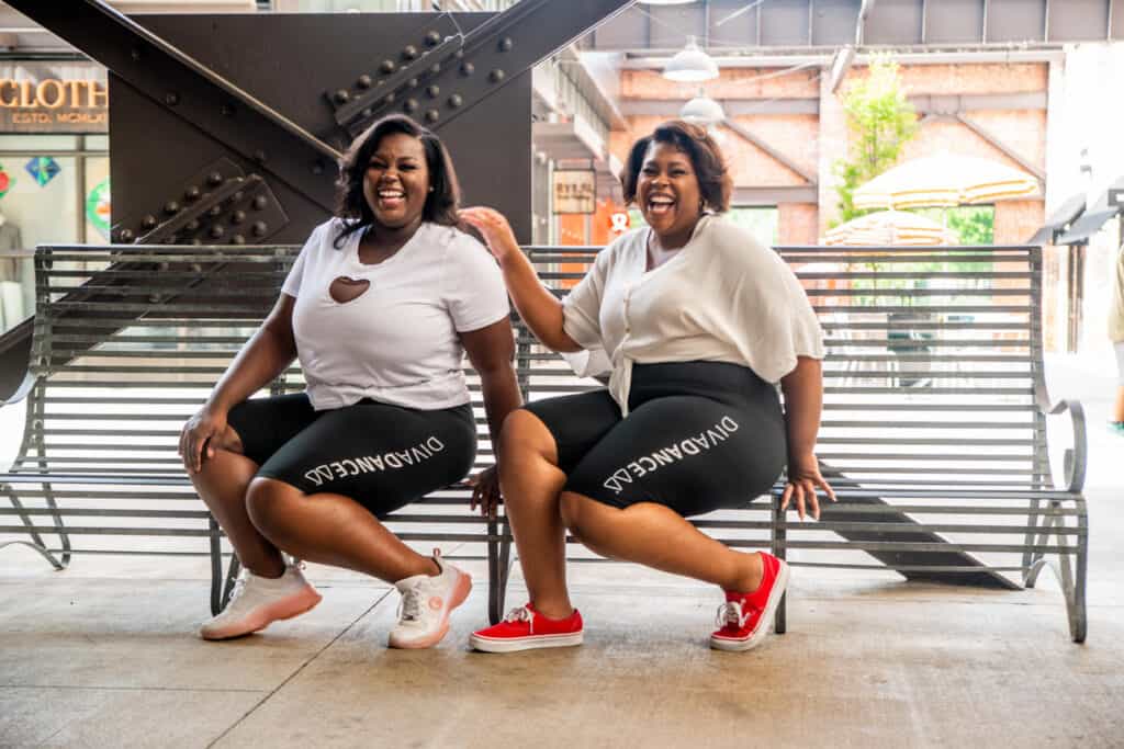 Two Black Women Sitting on a Bench Laughing