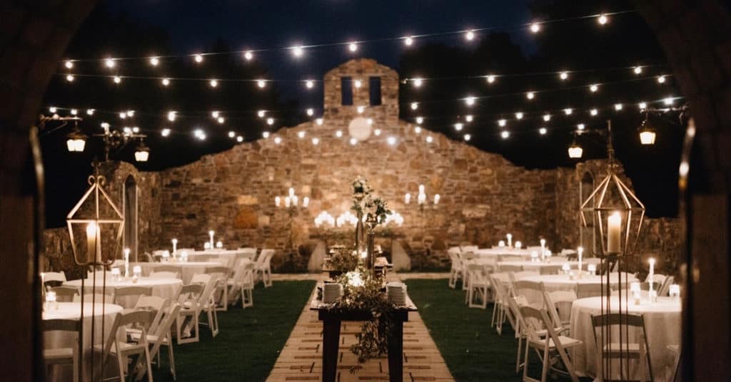 Tables with white linens at night at Sassafras Springs Vineyard