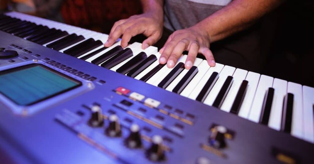 Closeup of a man's hands playing a keyboard at Pete’s Dueling Piano Bar