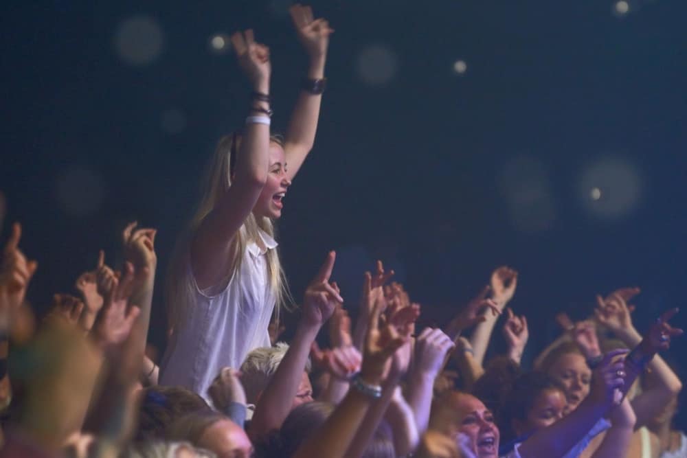 Woman enjoying a concert with hands in the air