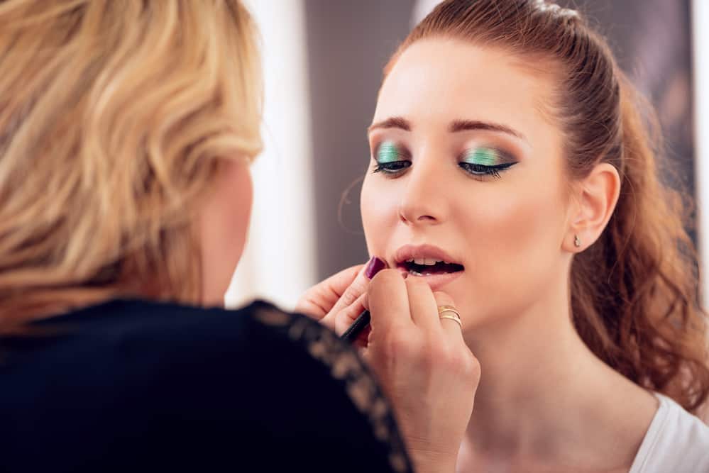 woman getting makeup done, lipstick applied