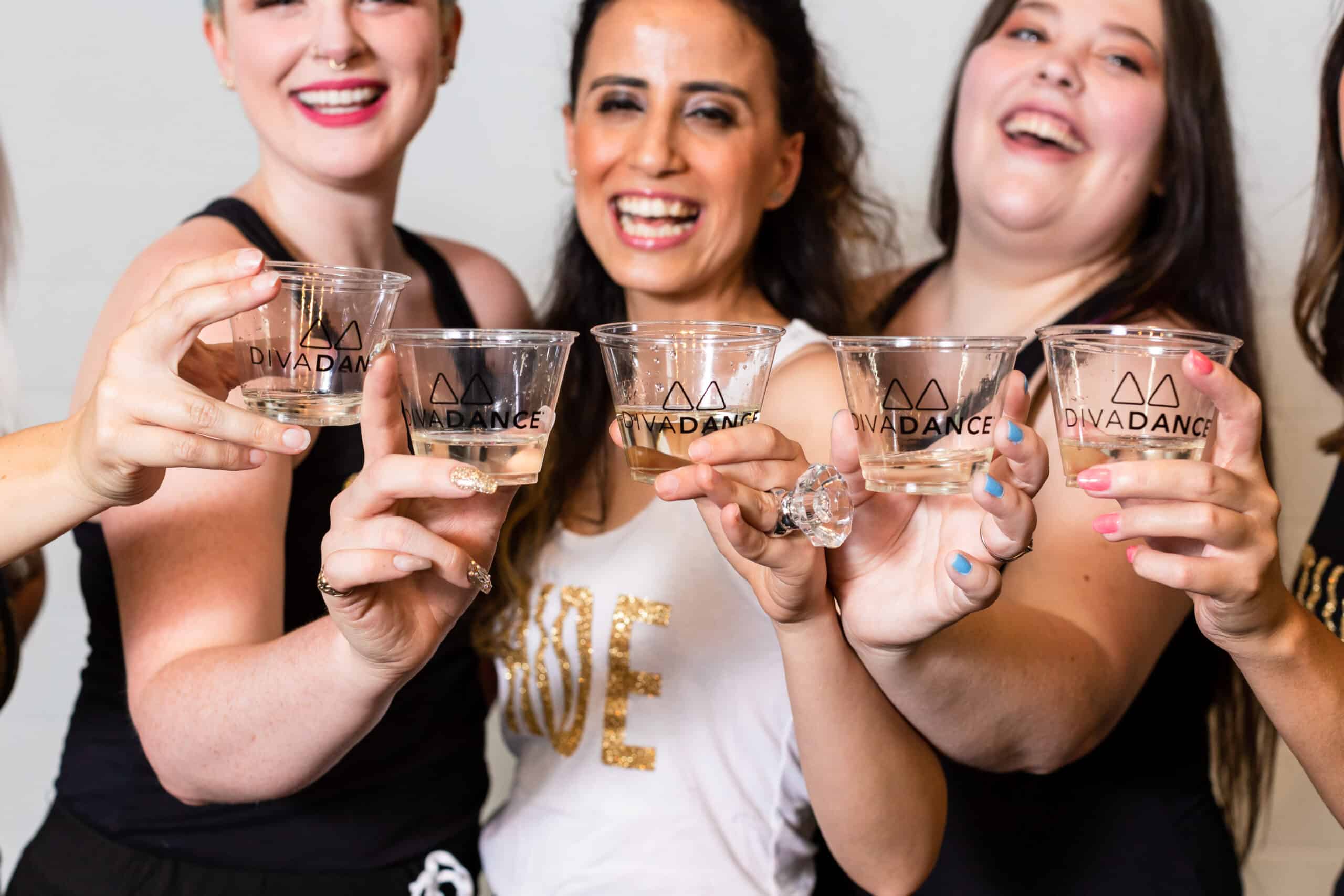 A group of women posing for a photo with wine glasses.