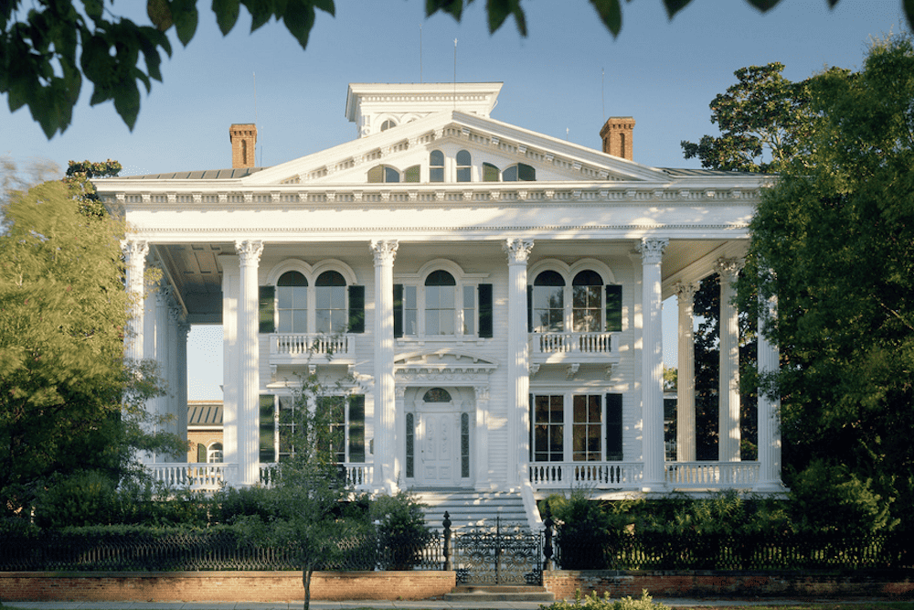 A white house with columns and a porch.