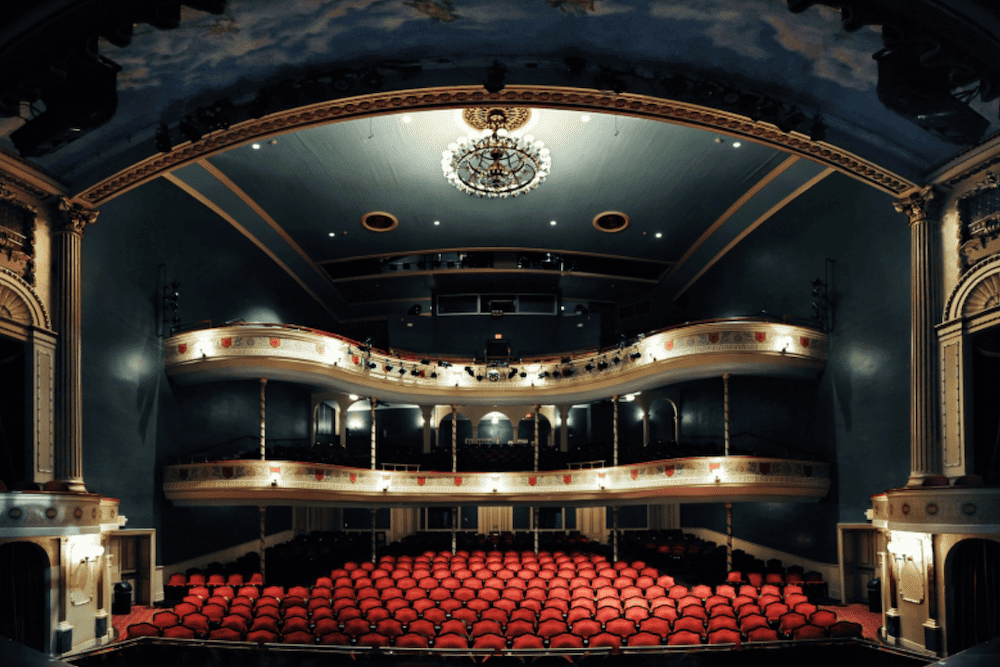 A large auditorium with red seats.