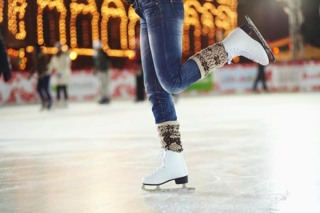 A person's legs on an ice rink.