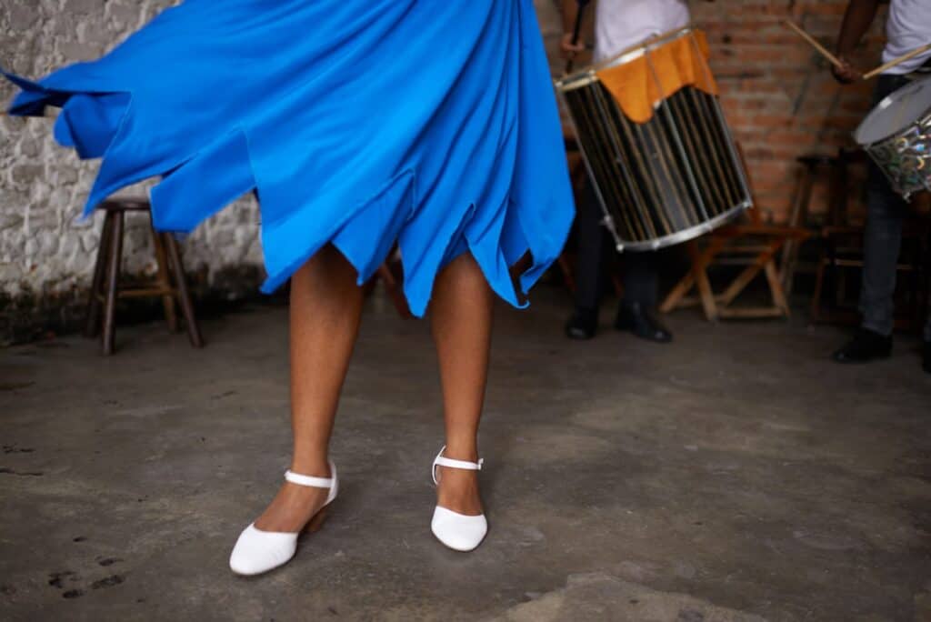 A woman wearing a blue dress and white shoes.