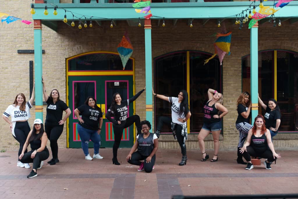 A group of women striking a pose in front of a building for their bachelorette party in Alamo City.