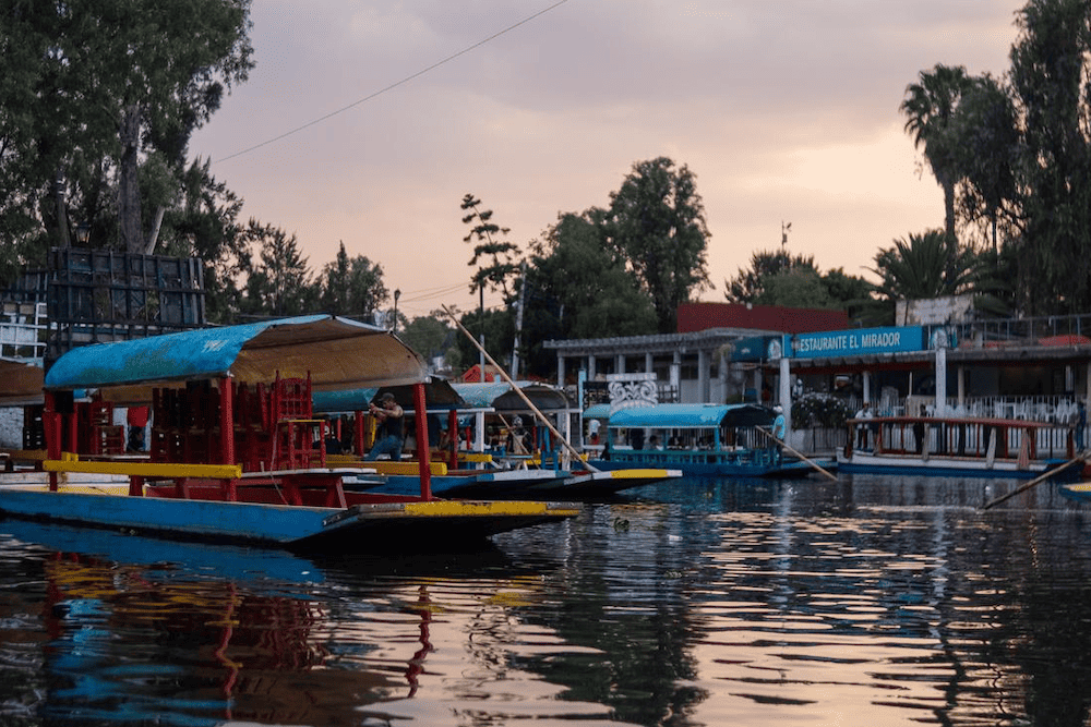 A group of boats docked on a river in Mexico City.