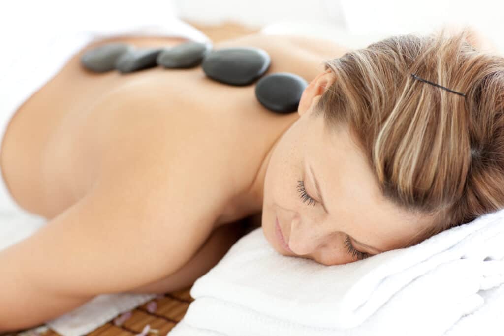 Woman receiving a hot stone massage on her back.