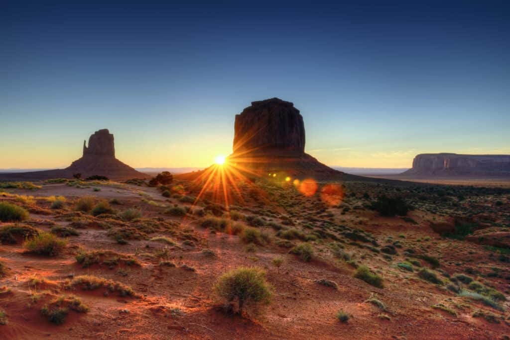 Sunrise between the rock formations of monument valley.